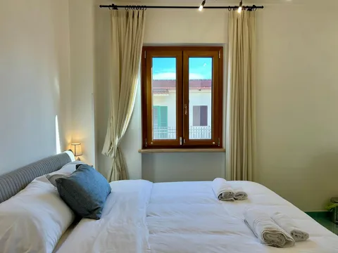 Camera con letto matrimoniale grande e tende color crema