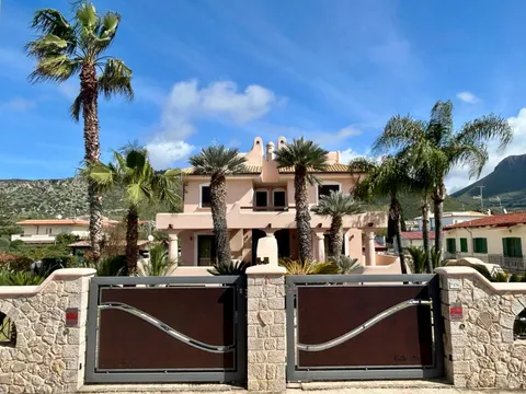 Il cancello di Villa Palmera, con le palme e la villa dietro