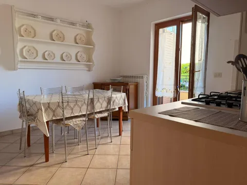 Cucina e zona pranzo con tavolo per sei