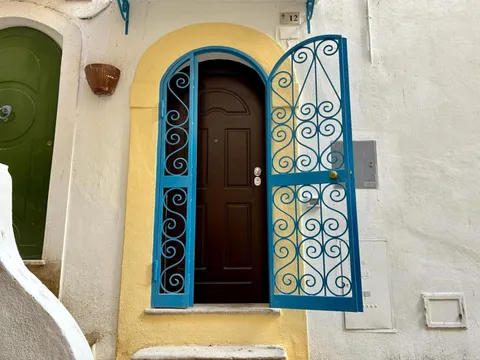 Una porta blu in un vicolo bianco del centro storico