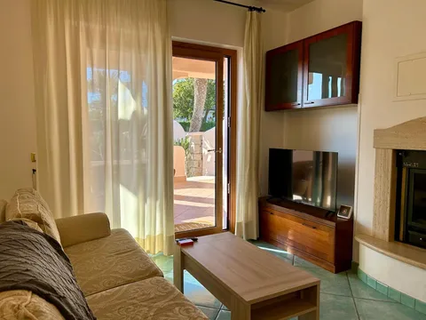 Soggiorno con divano, televisione e porta sulla terrazza
