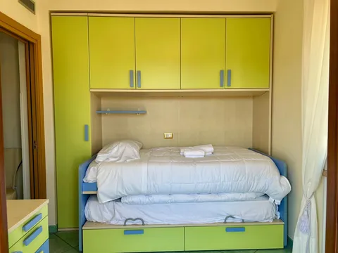 Camera con letto estraibile e armadi gialli
