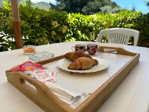 Cornetti e due tazzine su un vassoio, nella zona pranzo all'aperto